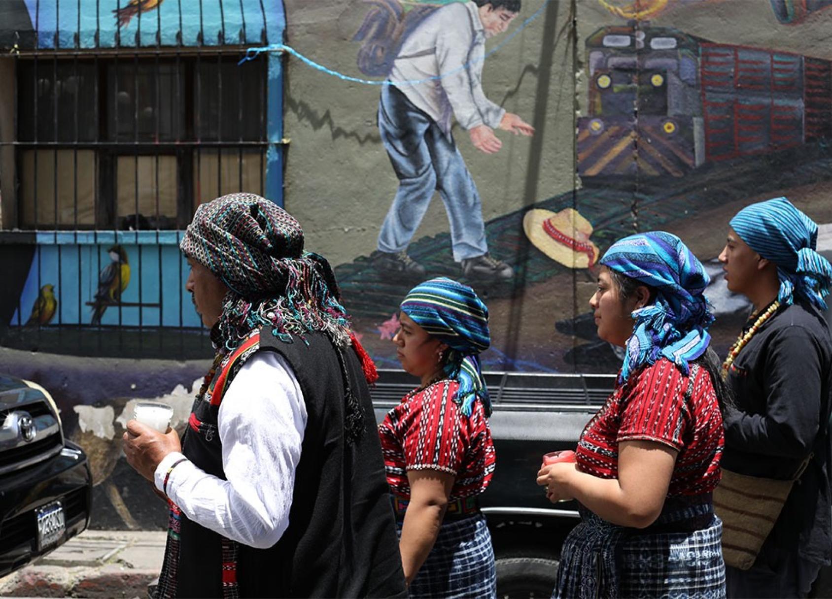 Indigenous community members walk down a street in Guatemala.