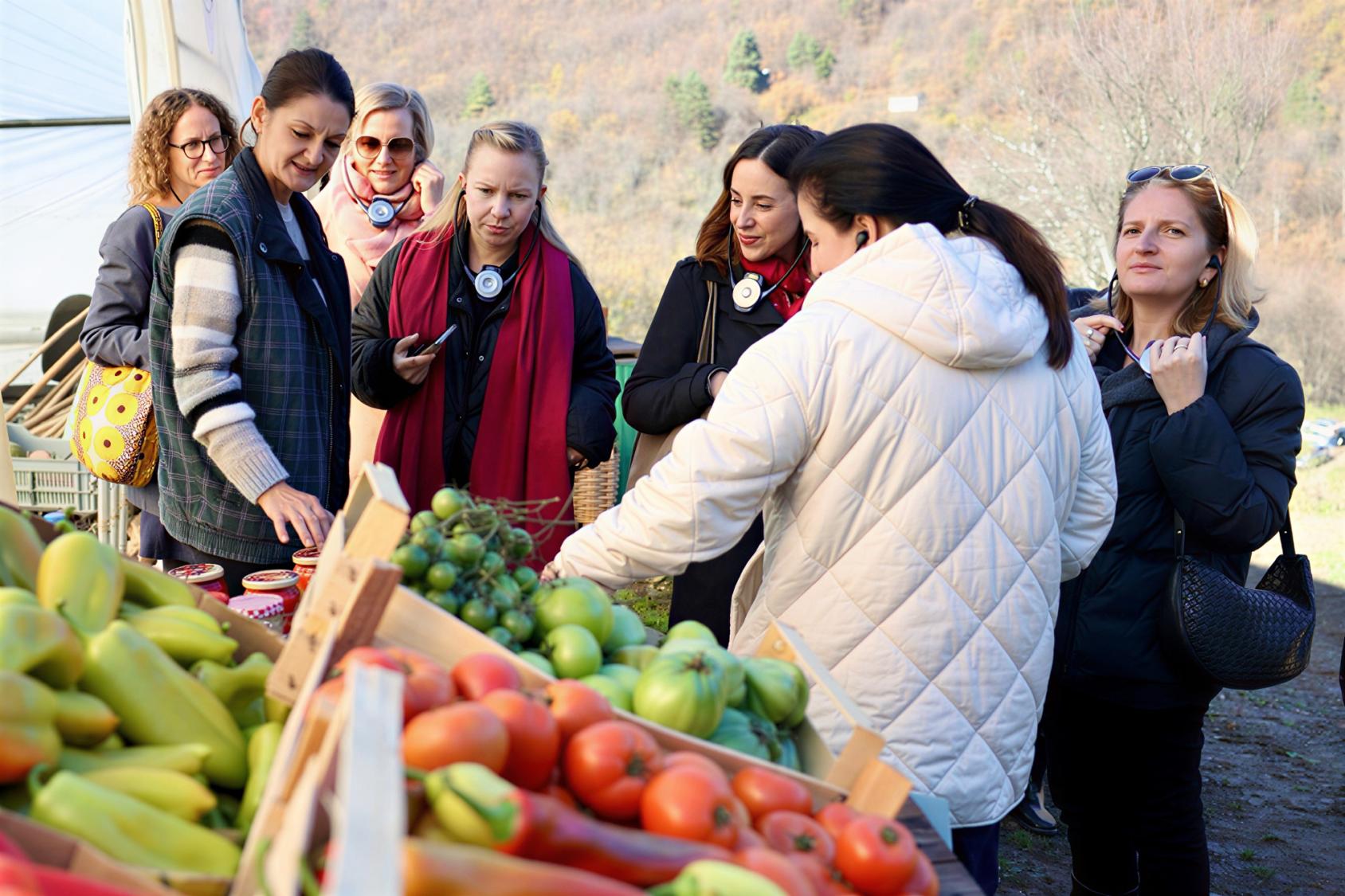 Bosnian women farmers meet at a food stall.