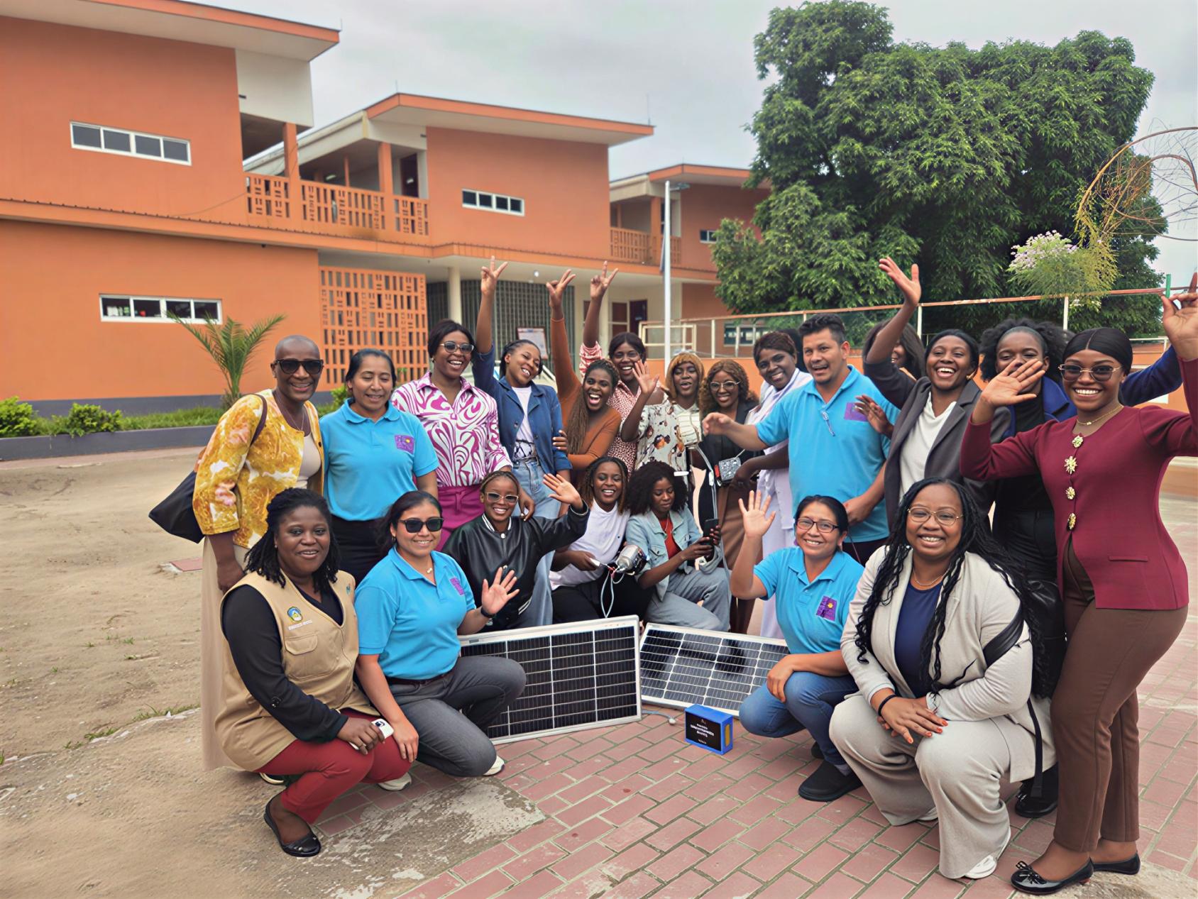 A group of women in Angola stands around a solar panel.