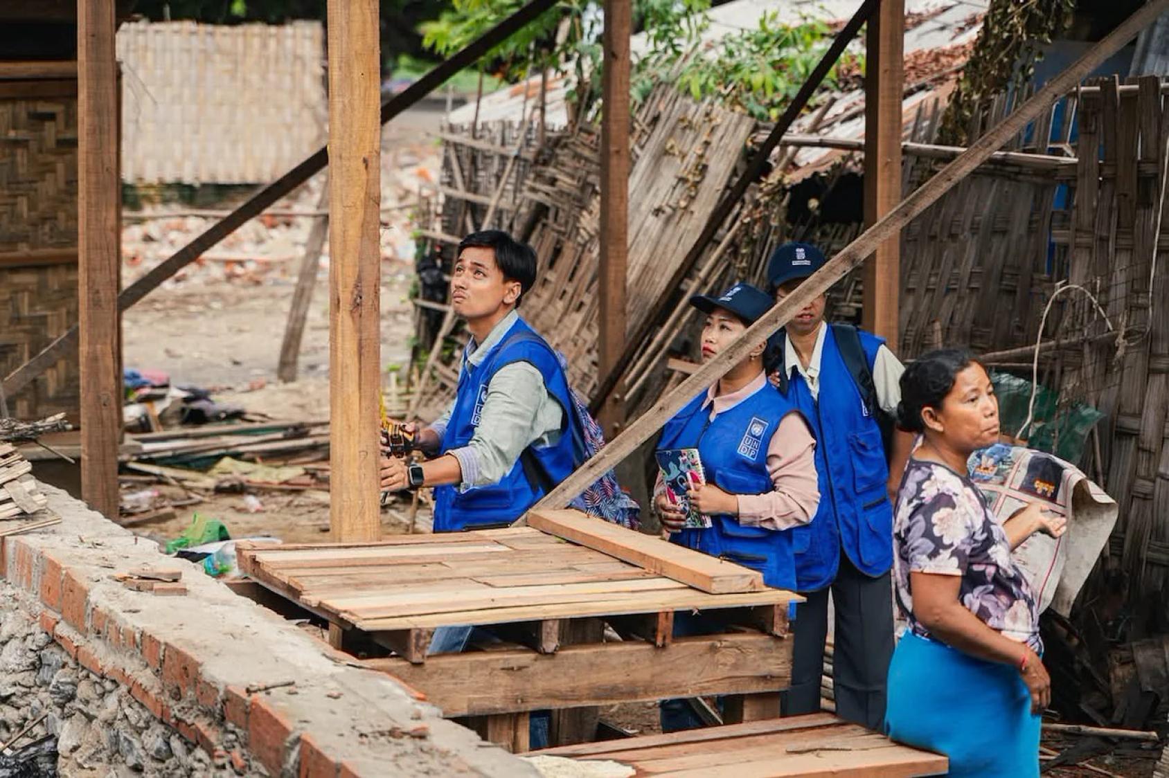 UN volunteers in Myanmar surveil reconstruction efforts after an earthquake.