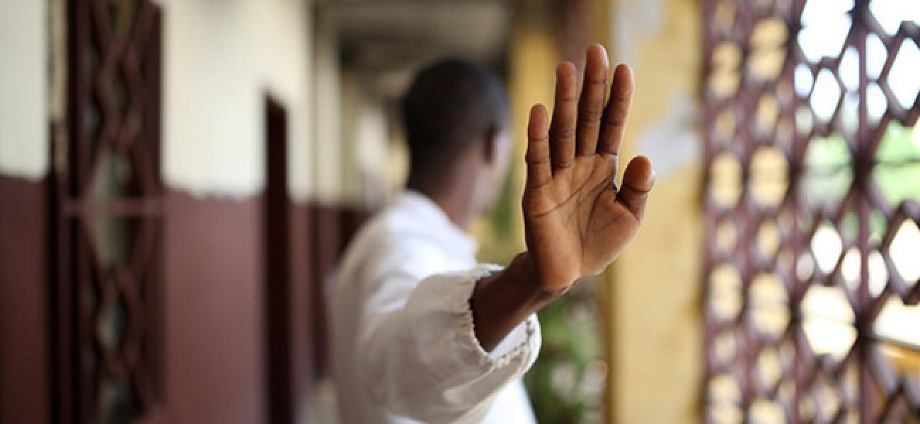 A person looking away with their hand up near the camera. 