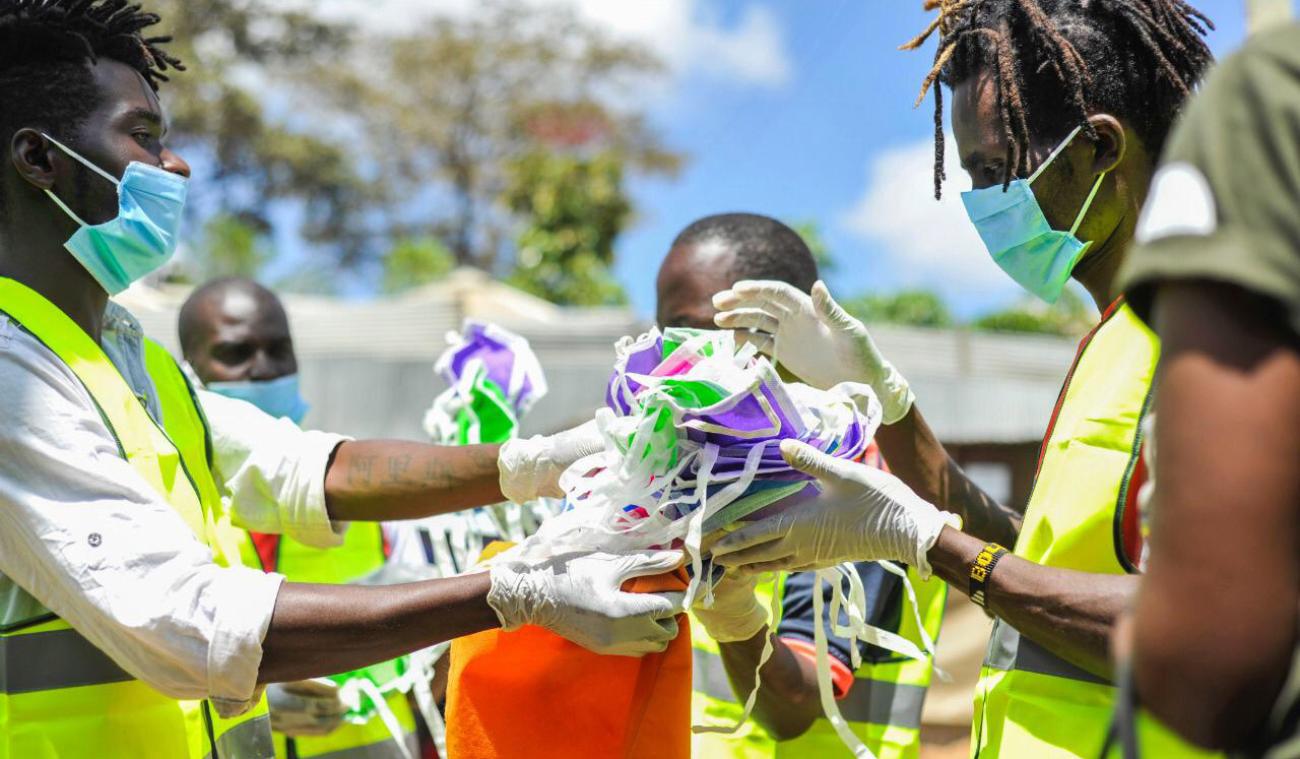 يقوم الناس بتوزيع الكمامات.