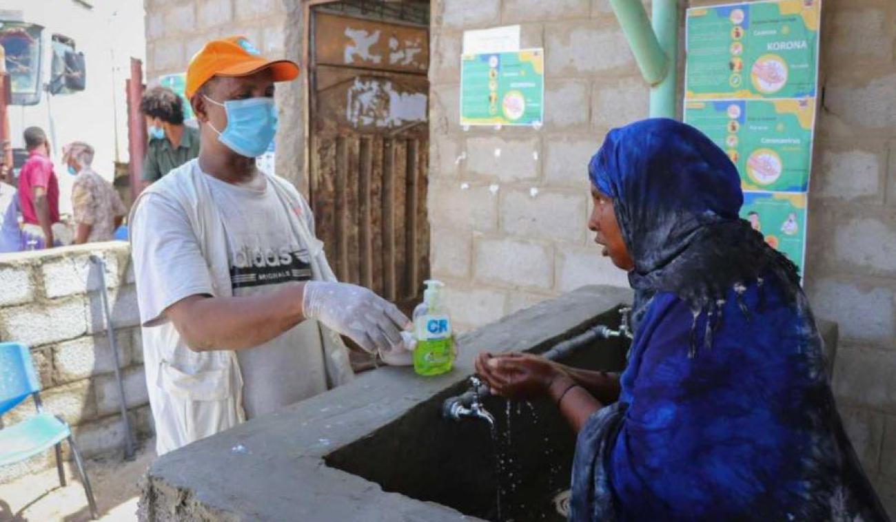 A man and woman take precautions against COVID-19 by using protective gear, hand sanitizer and thorough handwashing.