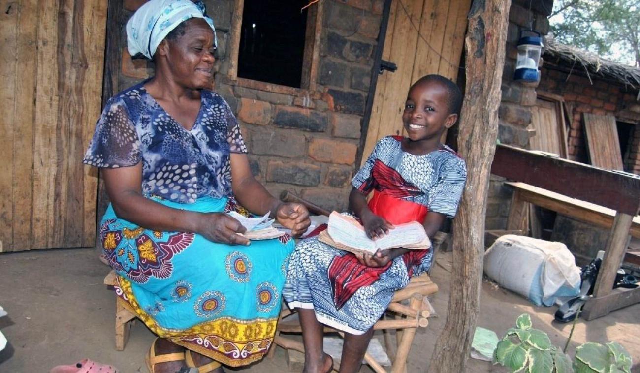 فتاة تدرس في المنزل بمساعدة والدتها.