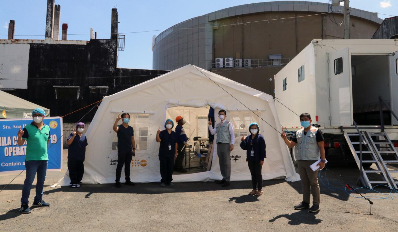 موظفون أمام خيمة صندوق الأمم المتحدة للسكان لفرز مرضى كوفيد في أحد المستشفيات في الفلبين.