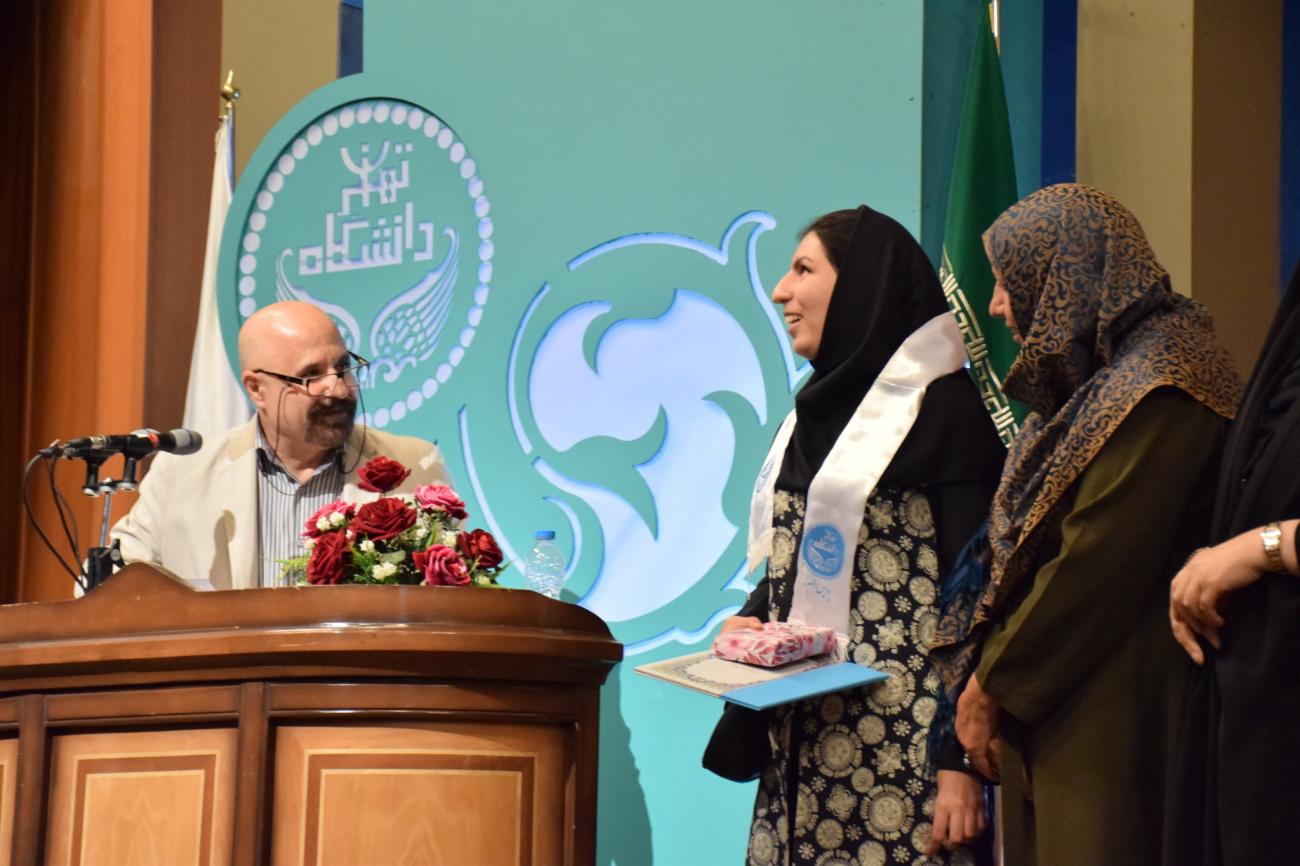 يقف أربعة أشخاص بالقرب من منصة مع خلفية خضراء.