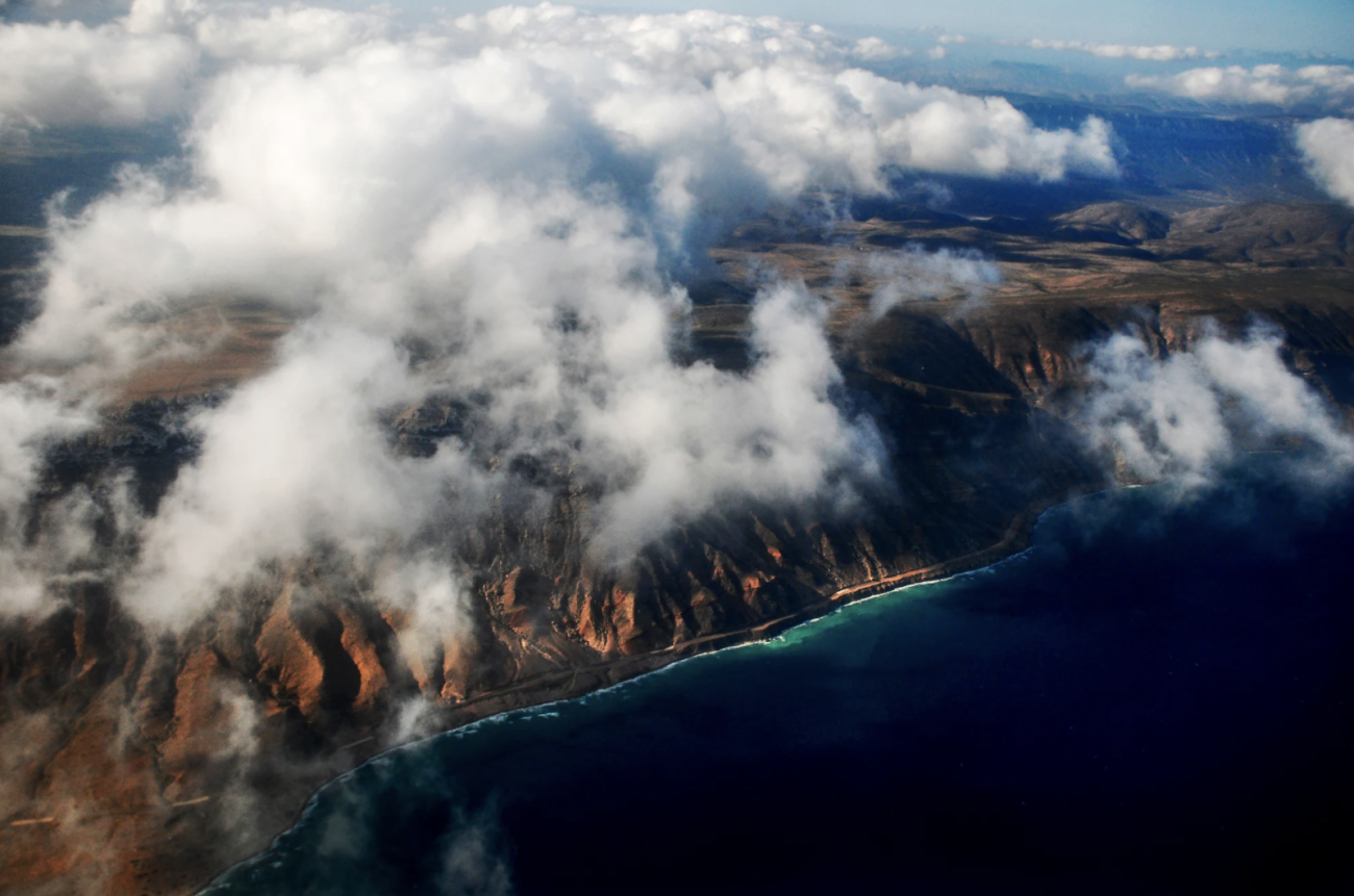 Una toma de área de una costa, con nubes en el cielo.