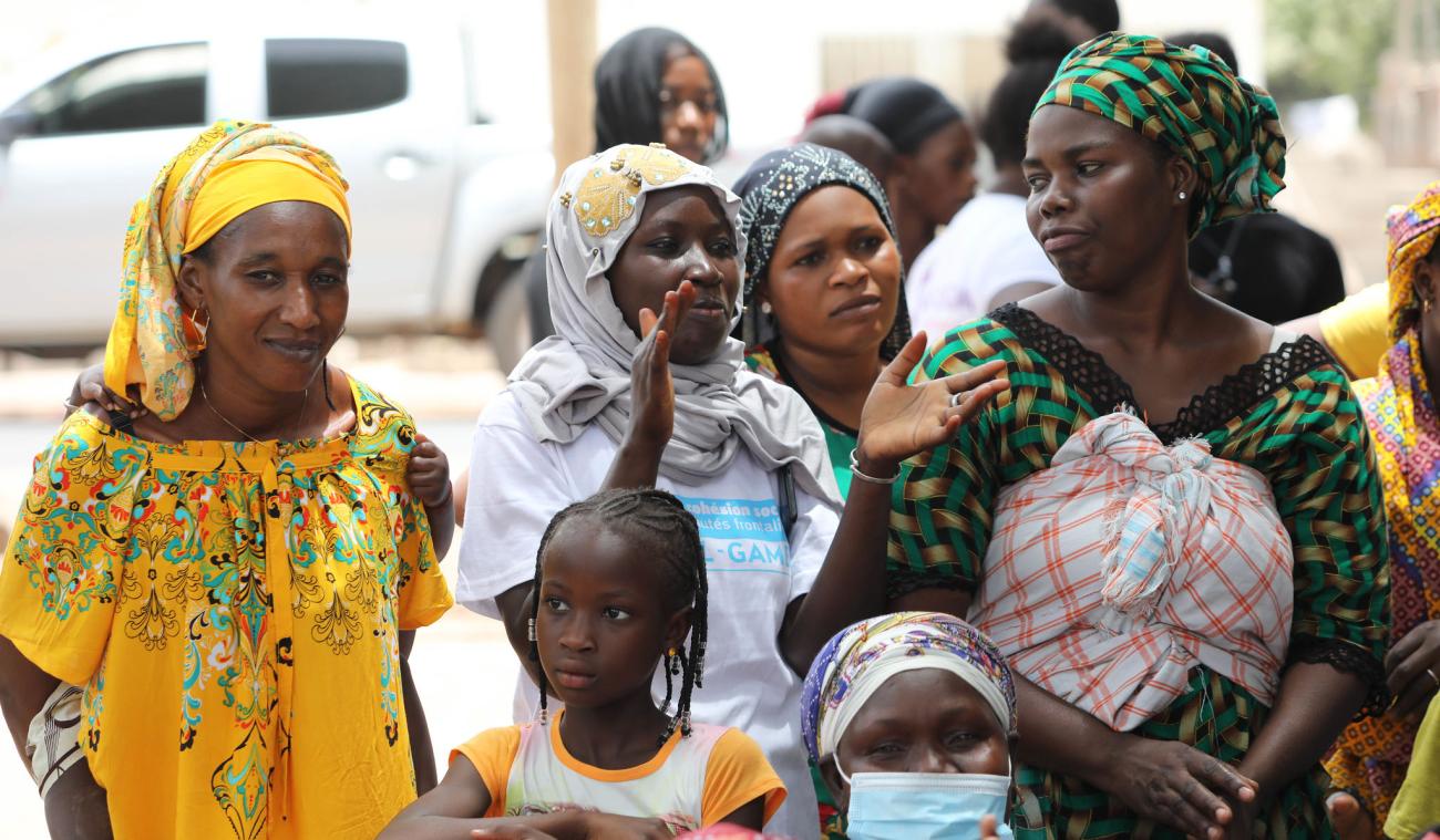 العديد من النساء والأطفال يتحدثون في الشارع.