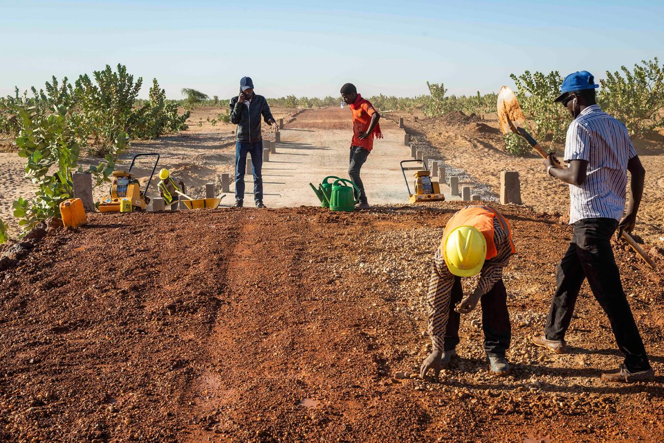 Una imagen de cuatro personas trabajando en una obra en el desierto.