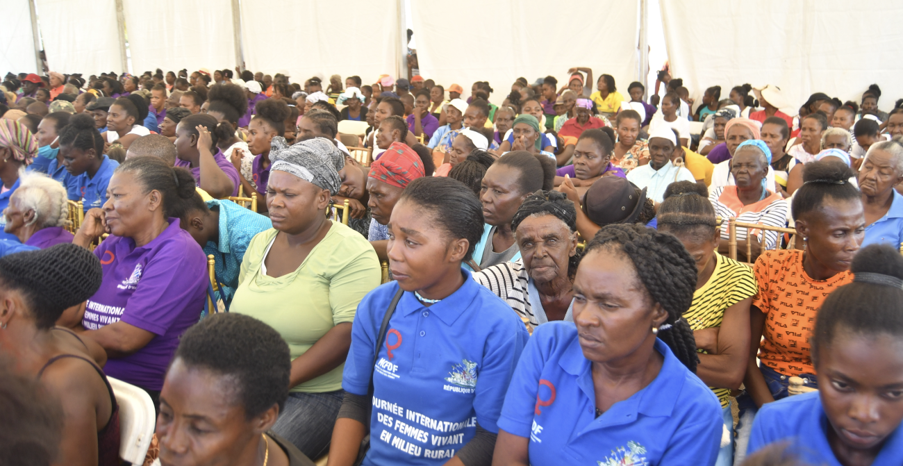 Des femmes de tous âges sont assises les unes à côté des autres sur des chaises sous une gigantesque tente.