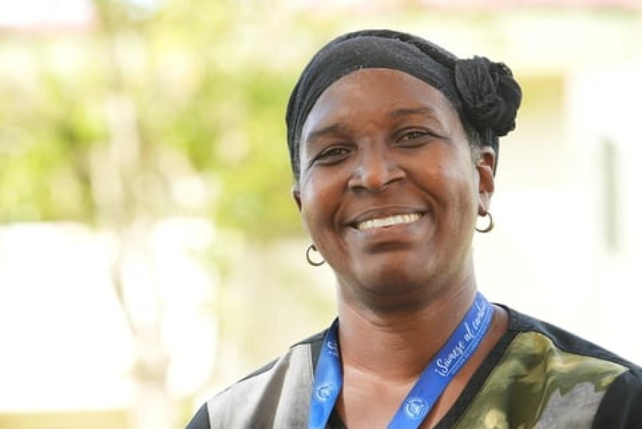 صورة لامرأة مبتسمة تنظر إلى الكاميرا.