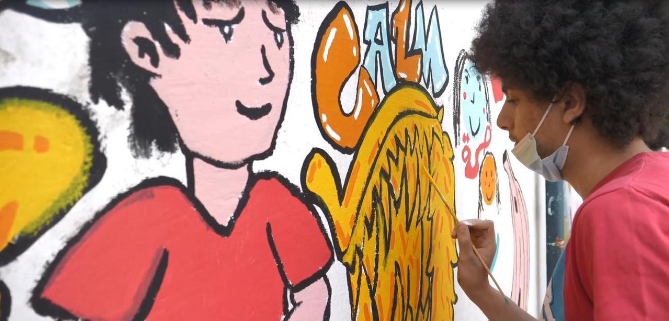 طفل يرسم جدارية علي حائط مدرسة خالد بن الوليد في بيروت التي تضررت من انفجار المرفأ وأعادت اليونسكو تأهيلها.