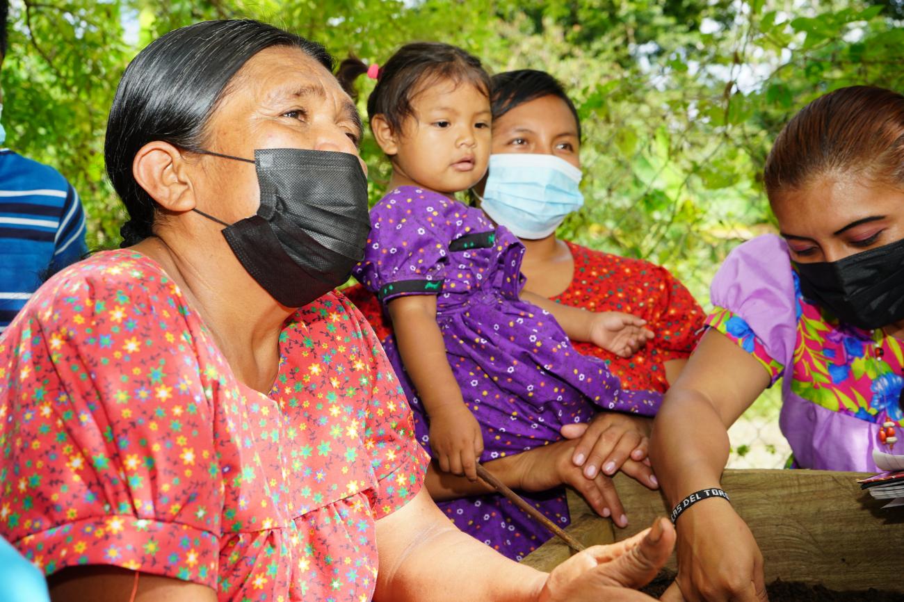 Tres mujeres indígenas Naso Tjër Di y una niña en su huerto comunitario.