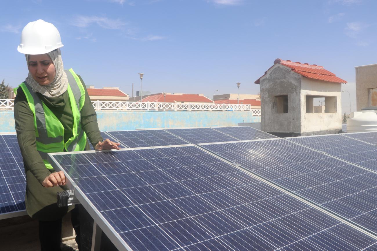 امرأة تصلح الألواح الشمسية.