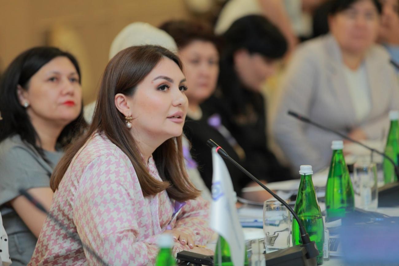 امرأة تجلس في غرفة اجتماعات أمام ميكروفون.