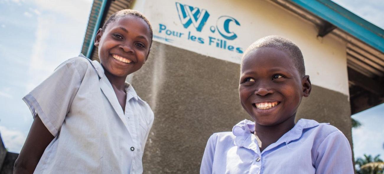 刚果民主共和国西部开赛省卡南加迪科莱拉伊小学厕所外的两名学生卫生队员在面对镜头微笑。