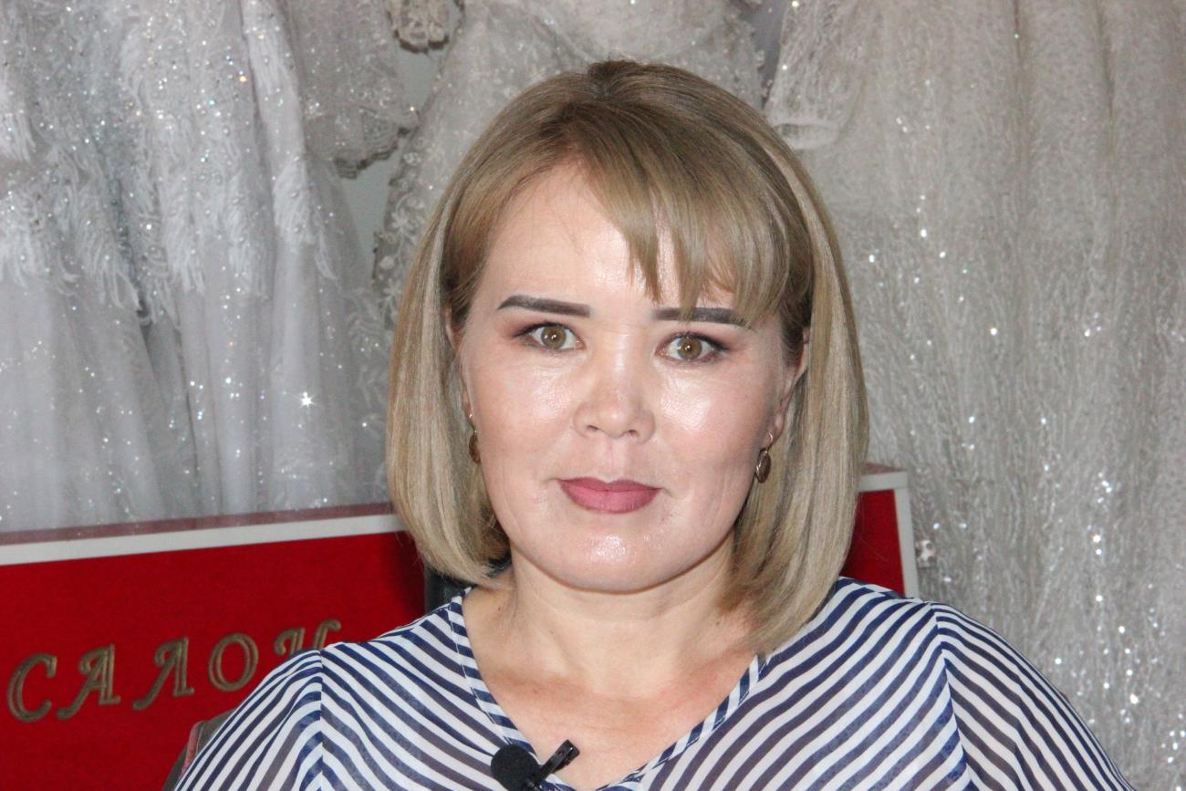 Woman in a striped shirt in front of a grey background