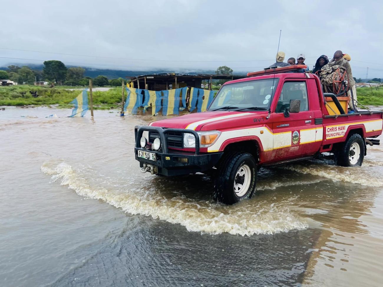 Red rescue truck in South Africa wading through water with people in it