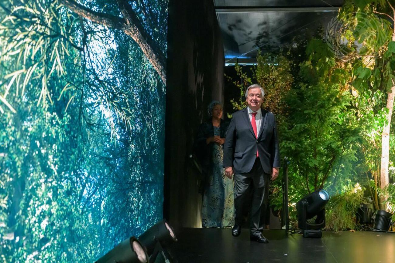 The UN Secretary-General stands inside an art exhibit depicting climate change