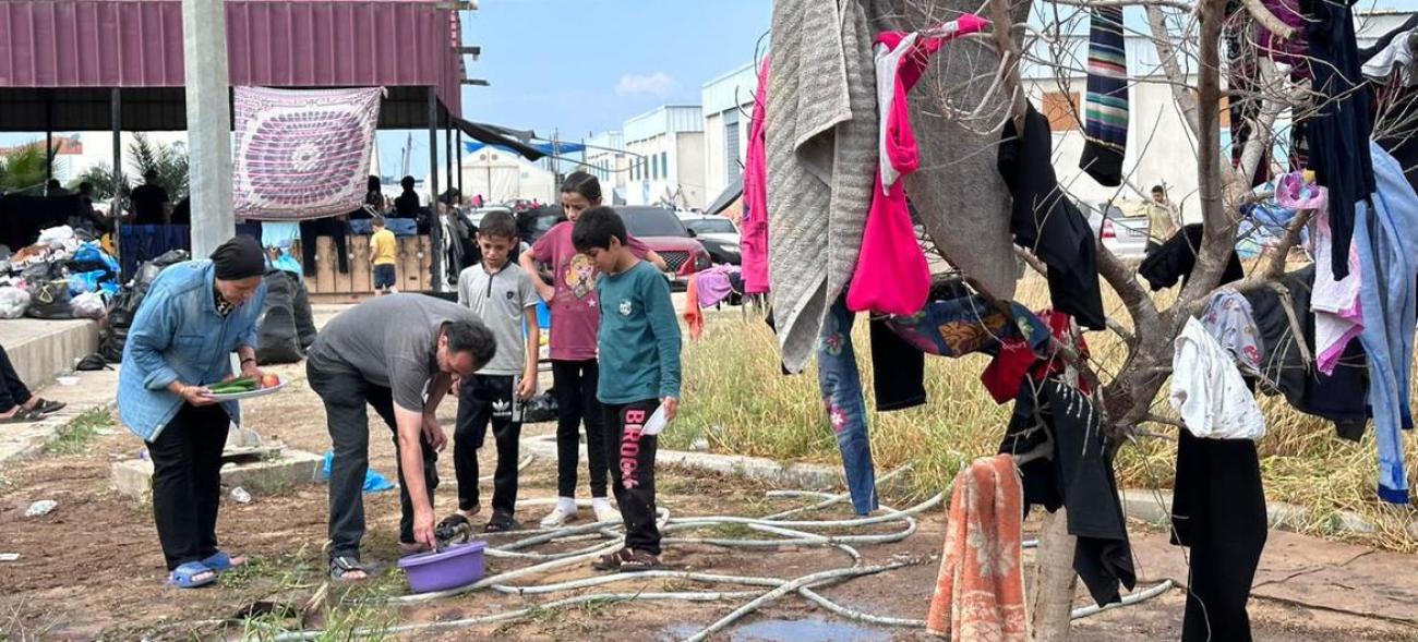 A group of displaced Gazans wash and hang clothes in a crowded space