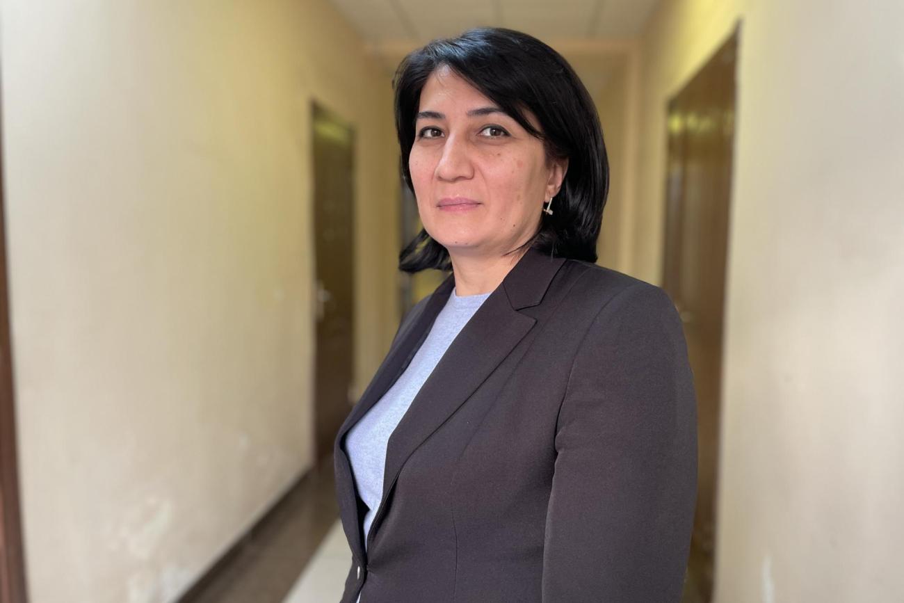 Фотография женщины, Нигоры Шоматовой, в пиджаке на фоне коридора