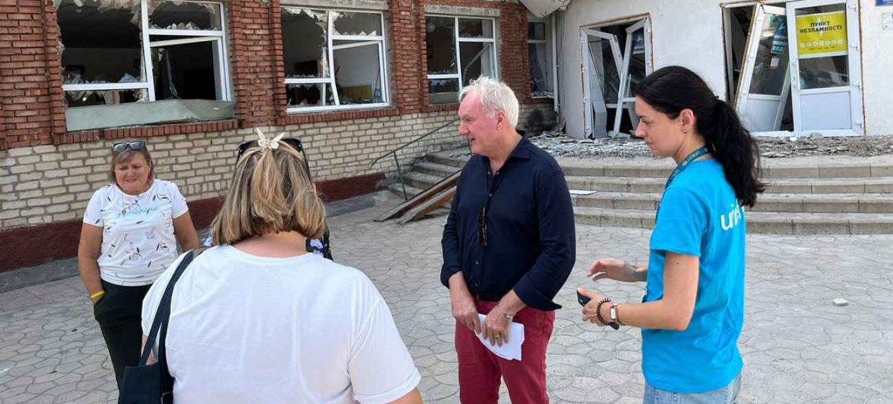 Resident and Humanitarian Coordinator for Ukraine Matthias Schmale (2nd from right) stands in front of a transit centre for displaced people fleeing hostilities in the front-line Donetsk Region.