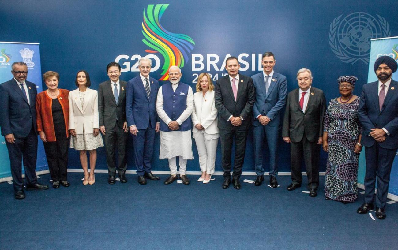 A group of 12 people, heads of delegations of the G20, standing in a line in various formal clothes