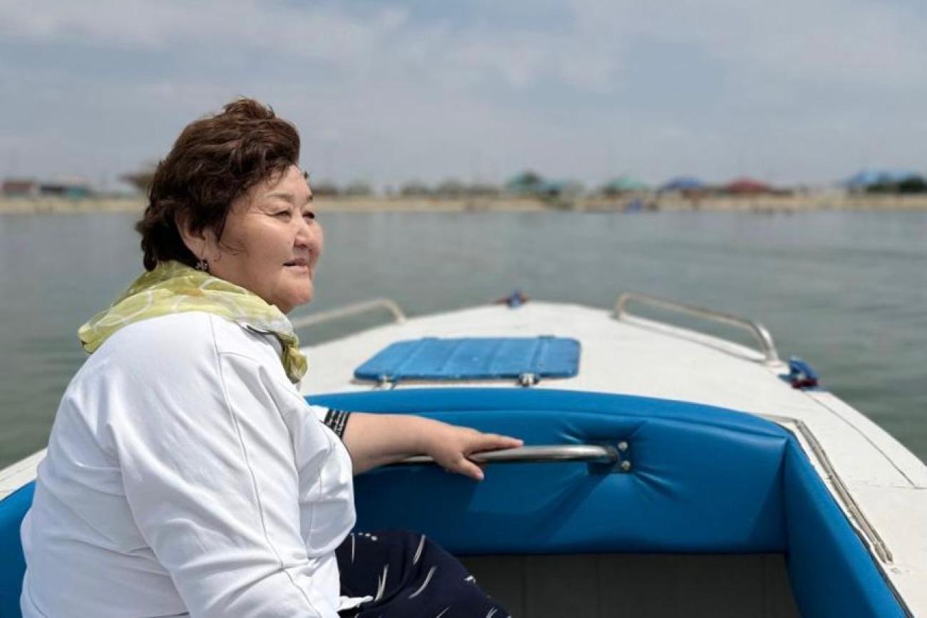 Женщина на моторной лодке плывет по озеру