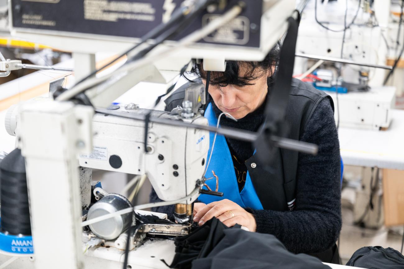 A woman uses a sewing machine while at work.