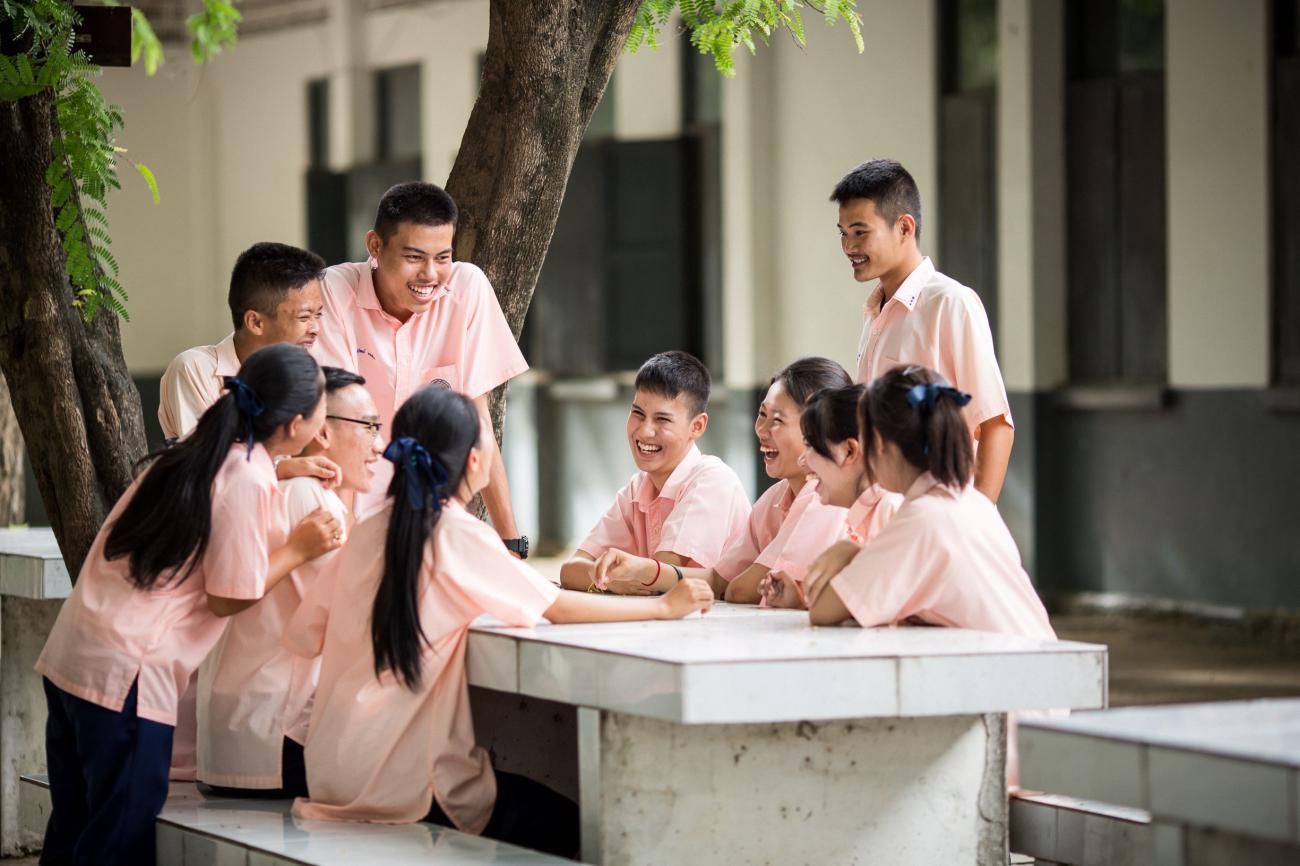 A group of young women and men sitting together and laughing