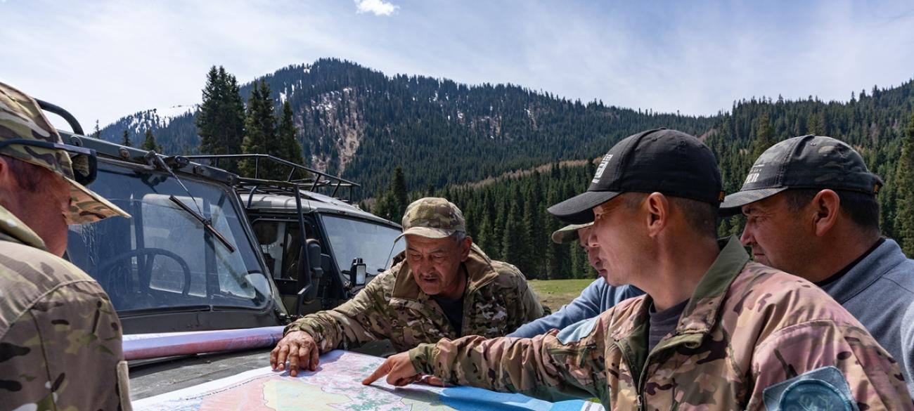 Егеря рассматривают карту местности в горах