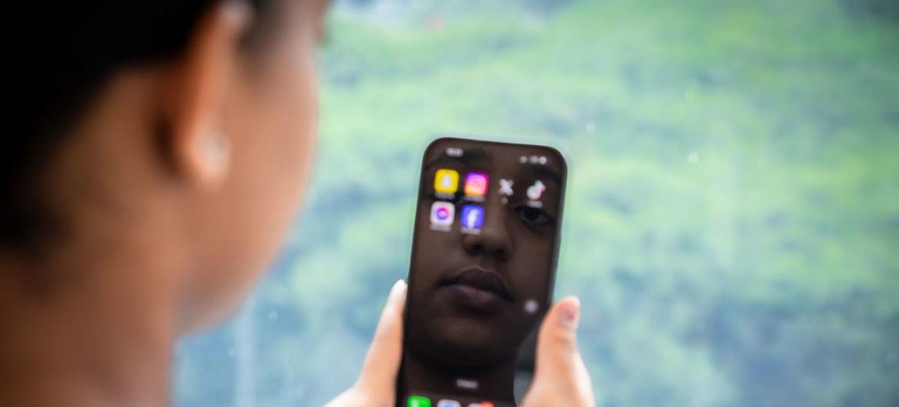 Una mujer mira la pantalla de su celular