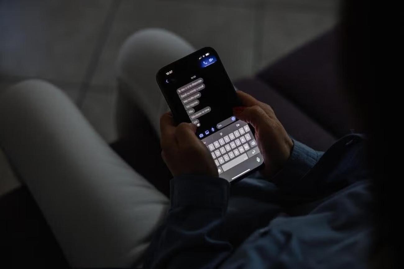 A girl holds a phone and reads her messages.