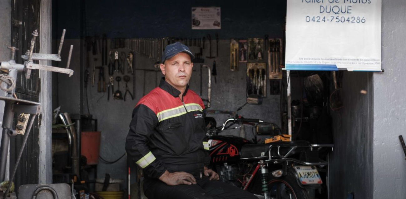 En el estacionamiento de su casa, Gerald Josué Duque ajusta un motor.