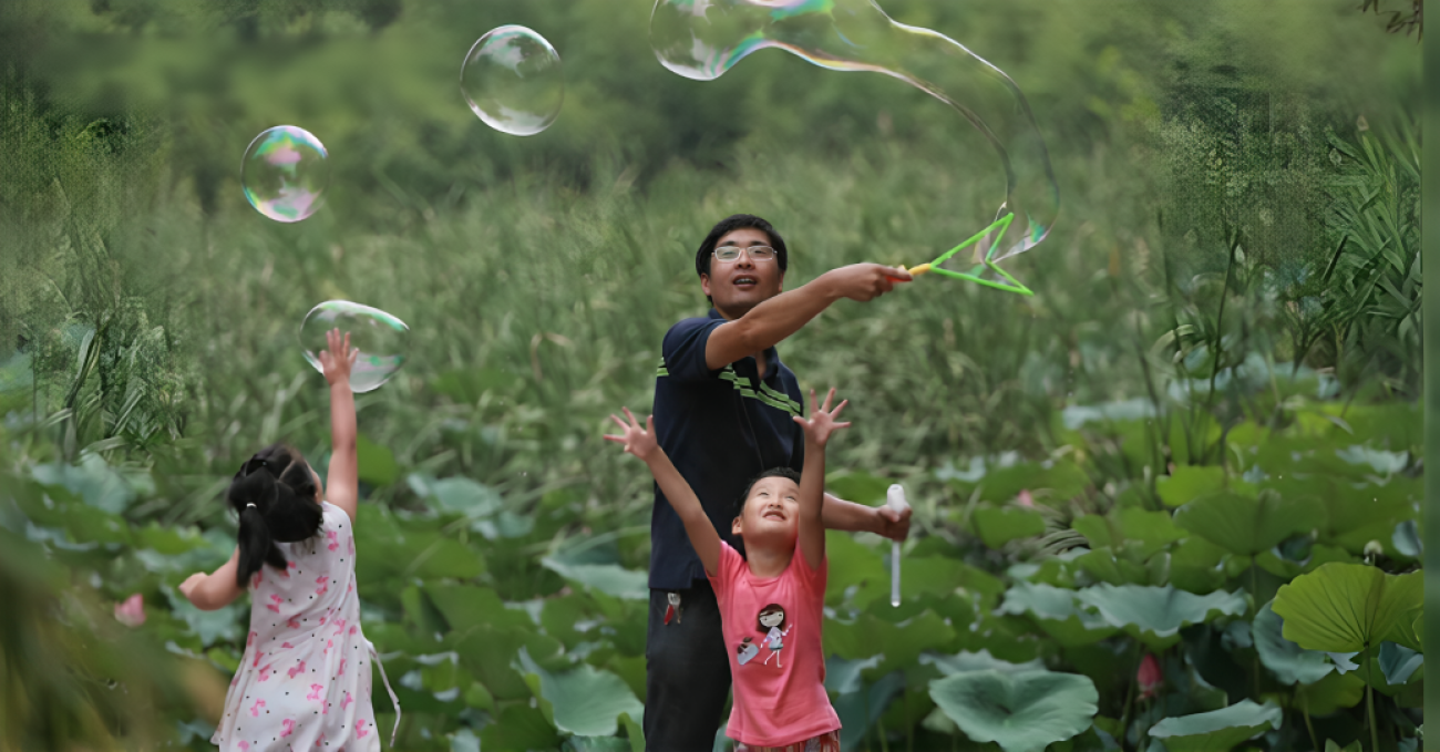 A man and his two daughters in China play with bubbles.