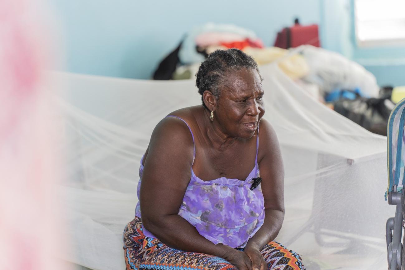 Sonia est assise sur un lit provisoire a l'intérieur du refuge