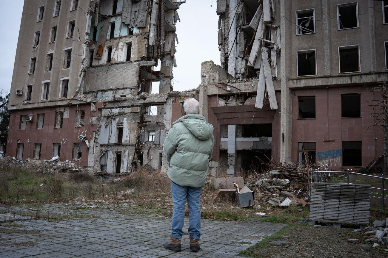 A high-level UN official surveils the damage to a building in Ukraine.
