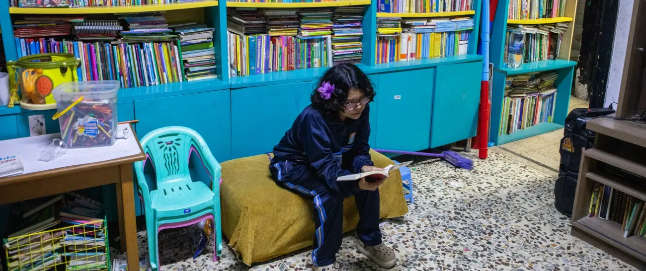 Niña leyendo en la biblioteca