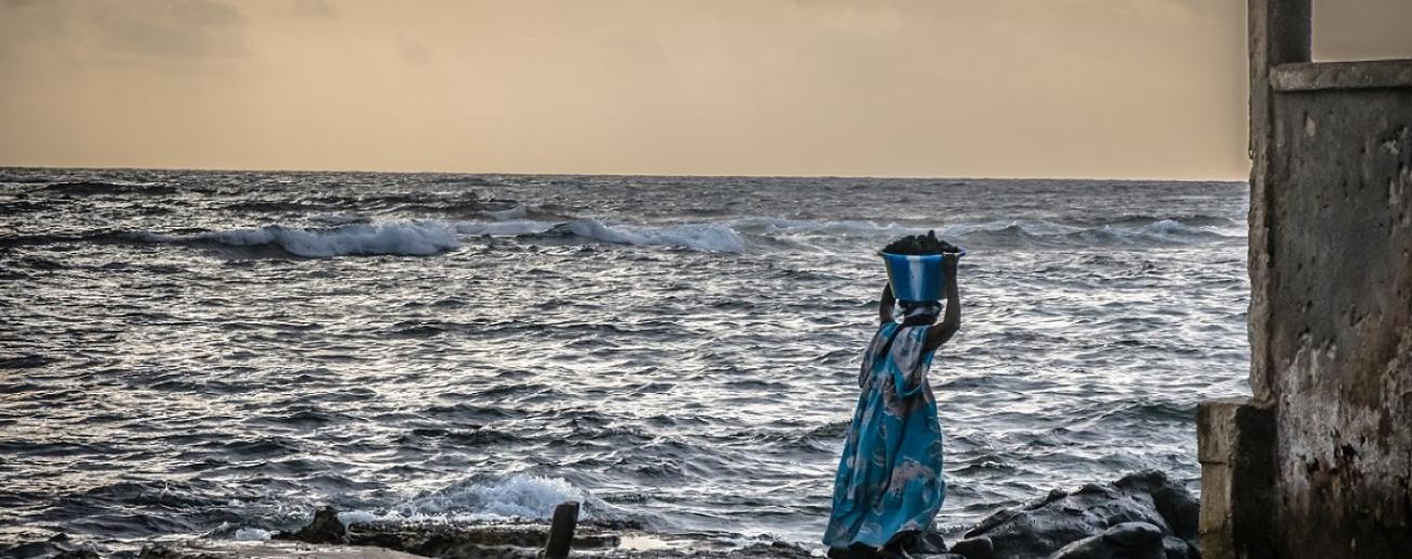 Au Sénégal, une femme porte un seau d'eau sur sa tête.