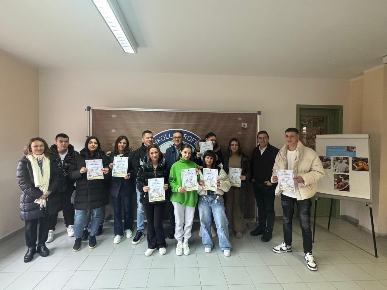 Группа молодых людей держит в руках сертификаты об окончании профессиональной подготовки.