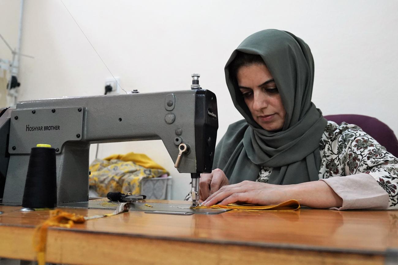 شابة في العراق تستخدم ماكينة خياطة