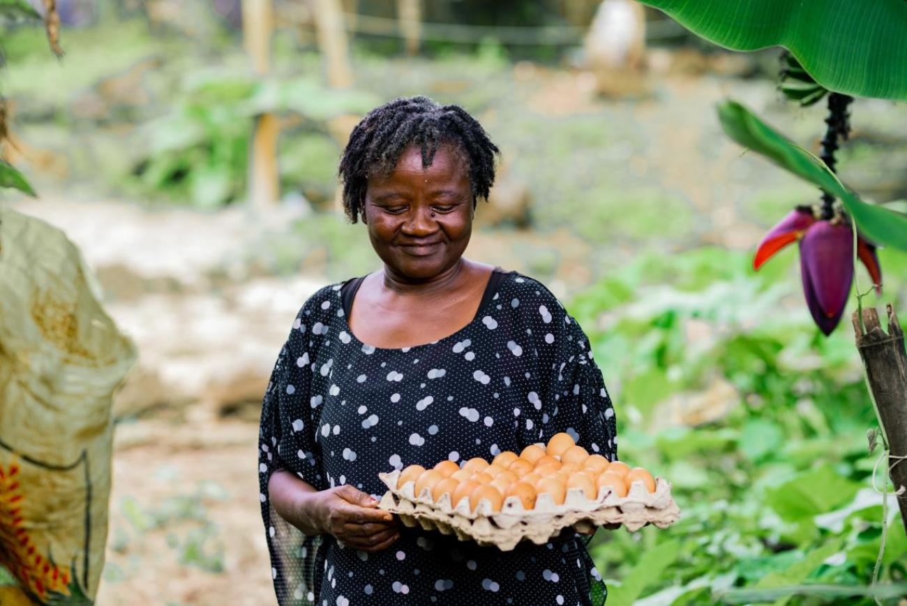 Une agricultrice camerounaise tient une boîte d'œufs.