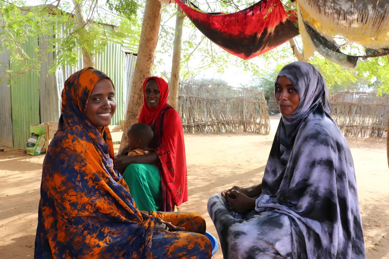 Three women in Kenya smile and laugh.