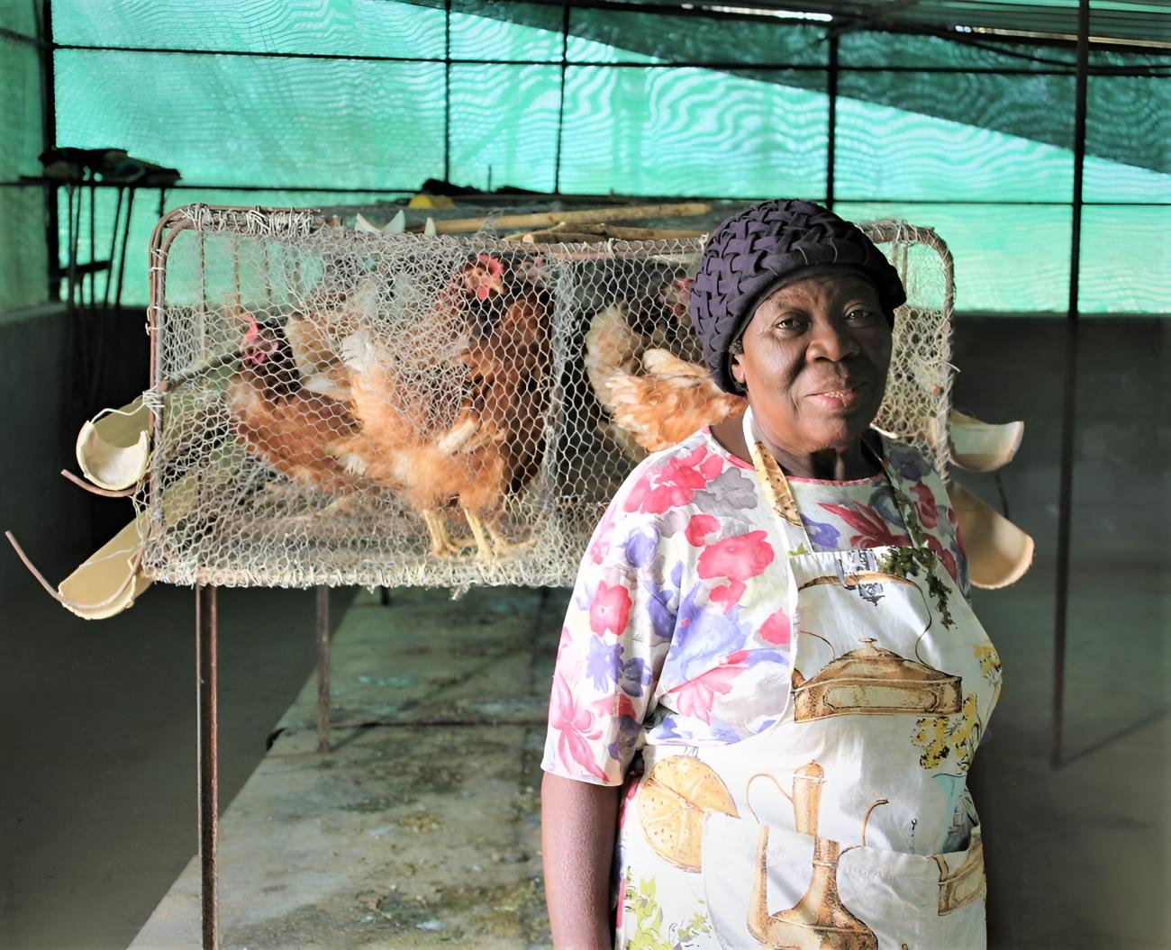 A woman farmer in Namibia in front of her chickens.