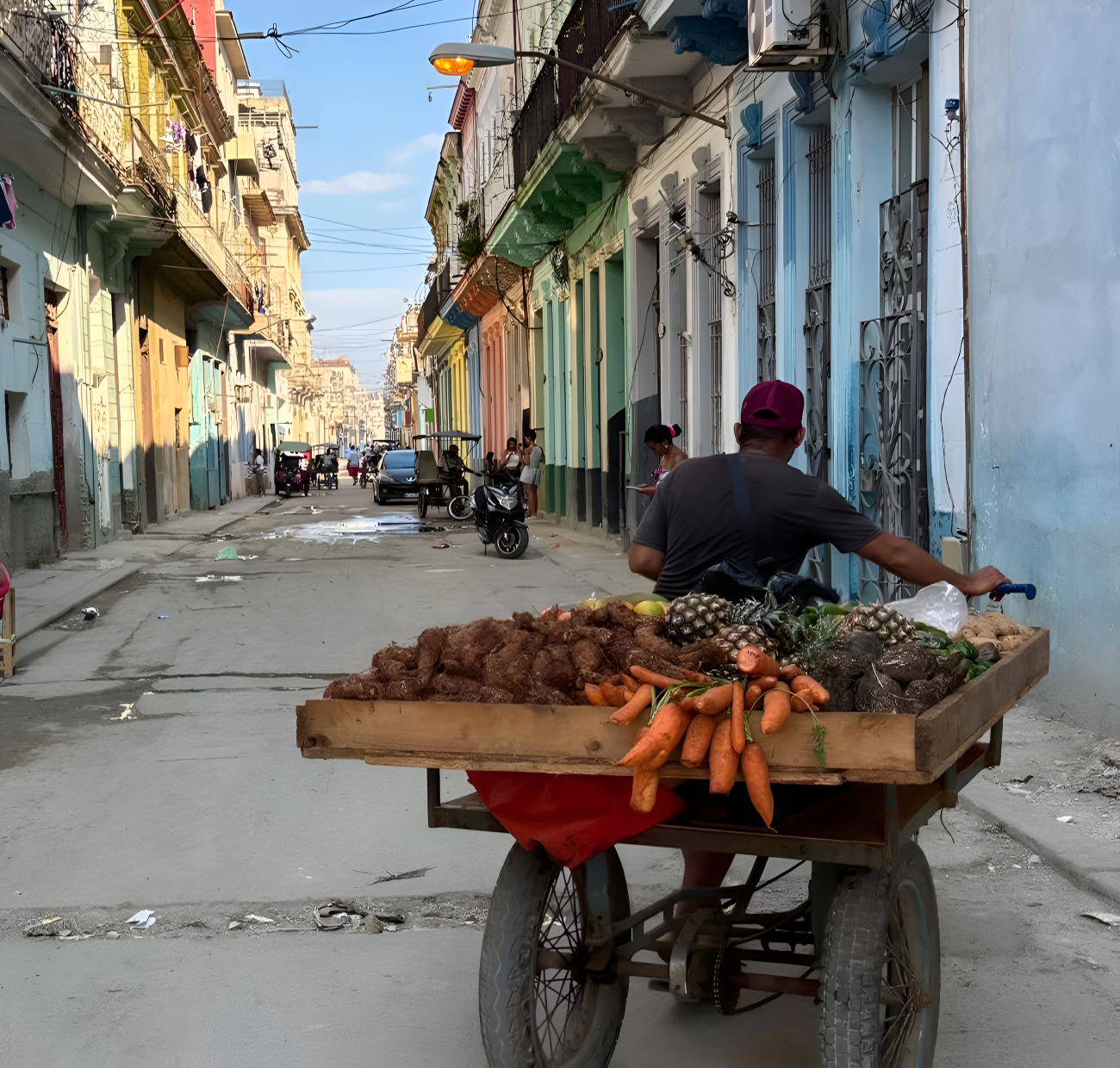 Un hombre en Cuba traslada su puesto de frutas.