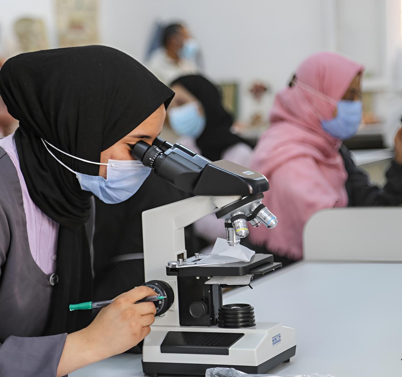 امرأة في ليبيا تنظر من خلال المجهر.