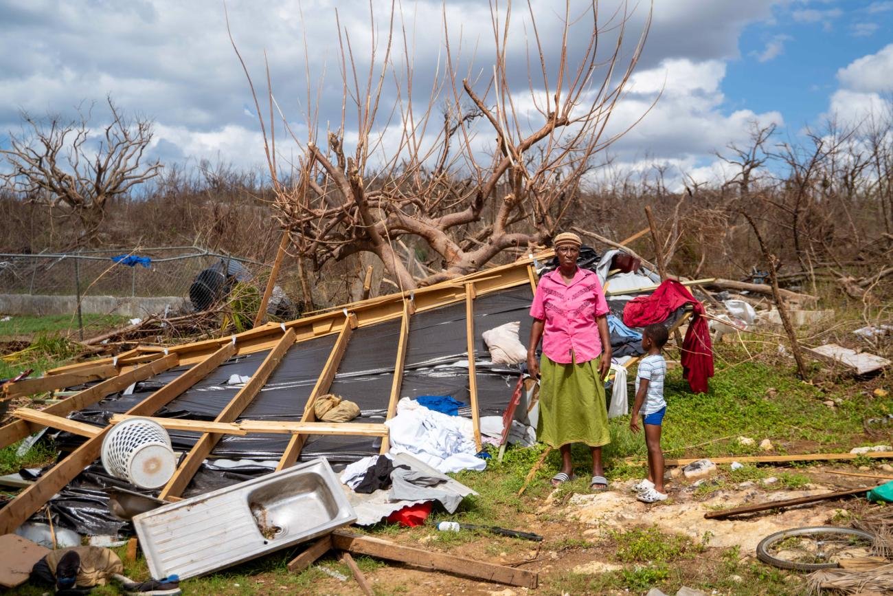 Una mujer y un niño junto a los restos de una vivienda destruida en una zona afectada por el huracán Melissa