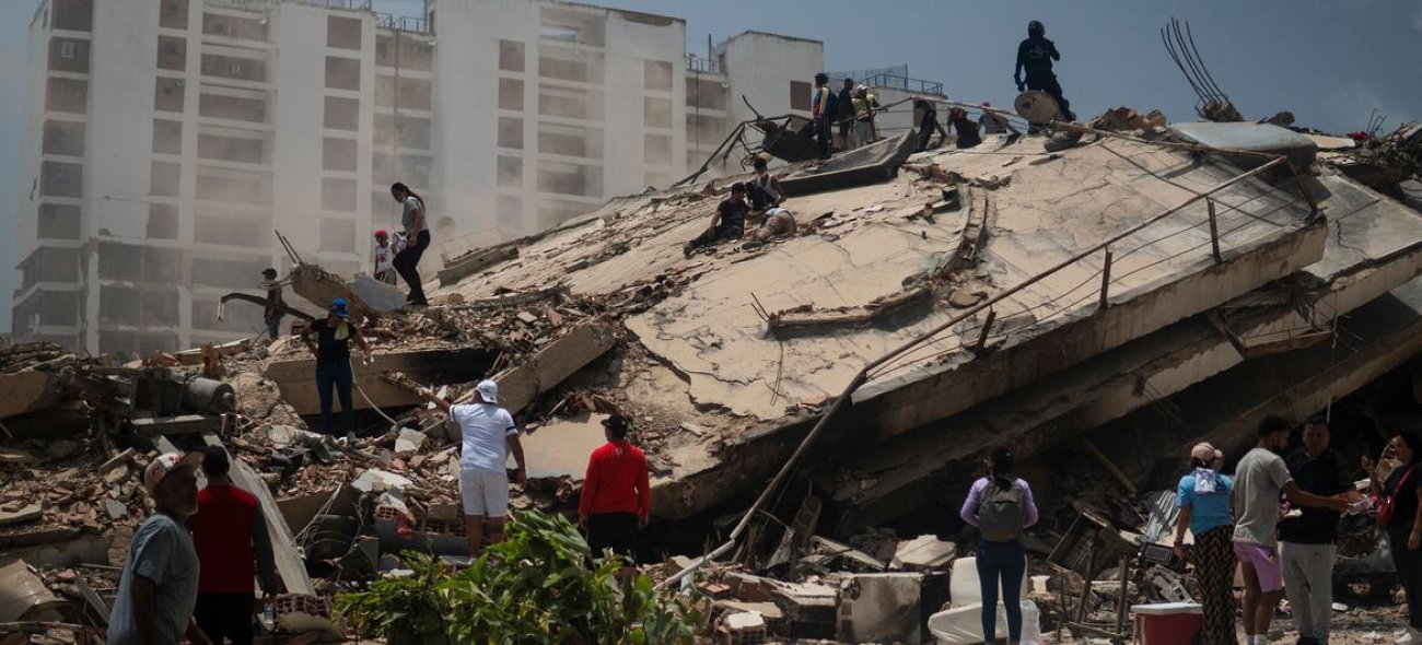 La gente busca entre los escombros de los edificios derrumbados en La Guaira, Venezuela.