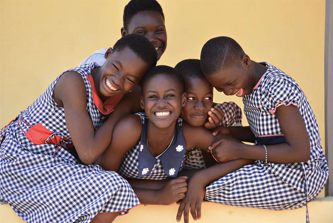 Five girls in Côte d'Ivoire smile for a photo.