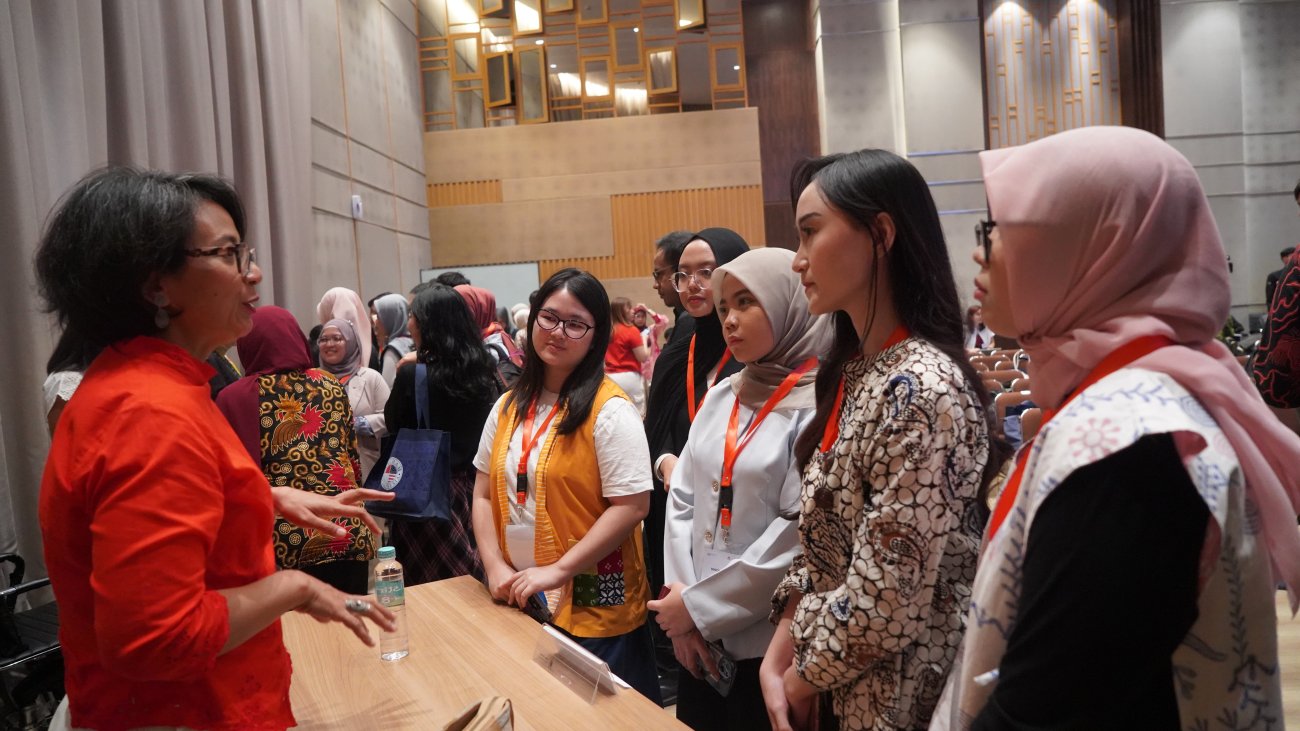 Young women leaders in Indonesia meeting senior executives at a forum.